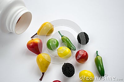 White bottle vitamins closeup table background closeup fruits vegetables healthy lifestyle Stock Photo