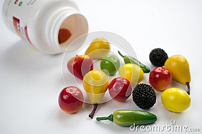 White bottle vitamins closeup table background closeup fruits vegetables healthy lifestyle Stock Photo