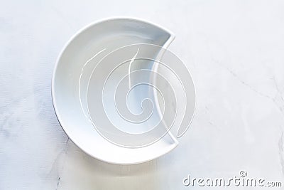 White bowl in the shape of a half-moon. Space for logo Stock Photo