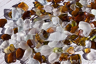 White, brown and green sea glasses, pebbles, background. Stock Photo