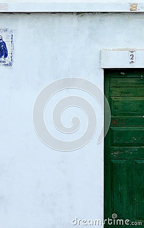 White building facade part with small window and green door Stock Photo