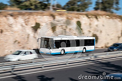 White bus moving fast along the street on a motion blurred background. Bus driving on freeway, Stock Photo