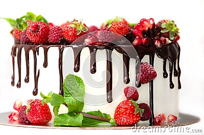 White cake poured with brown chocolate and decorated with berries on an isolated white background. Stock Photo