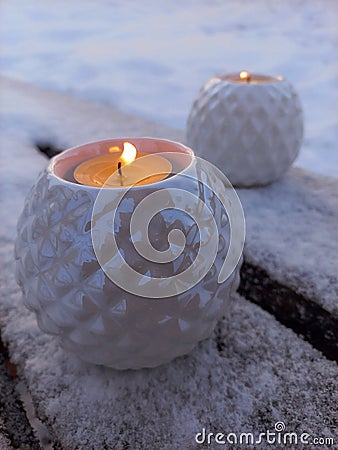 white candlesticks with candles on a wooden bench in winter Stock Photo