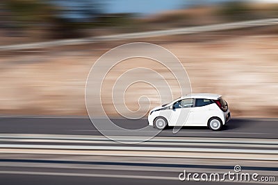 White car moving fast along the street on a motion blurred background. Car driving on freeway Stock Photo