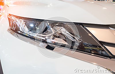 White car, outdoors. Predatory car headlight and hood of powerful sports Stock Photo