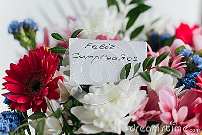 Card for a bouquet with the inscription happy birthday in spanish Feliz Cumplea os in a bright beautiful bouquet of flowers Stock Photo