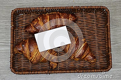 white card business above Fresh croissants in esparto halfah basket. Stock Photo