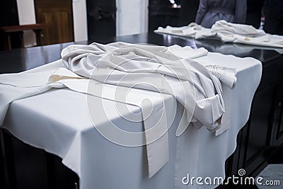 The white cassock of the priest lies on the table Stock Photo