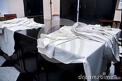 The white cassock of the priest lies on the table Stock Photo