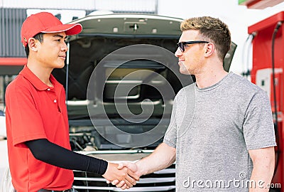 White caucasian car owner and Asian gas station worker man shake hands after succeed maintainance auto car engine and filling high Stock Photo