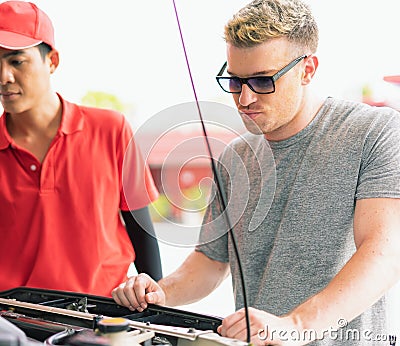 White caucasian car owner looks sad and looking at main auto car engine problem after filling high energy power fuel in auto car Stock Photo