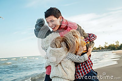 white Caucasian family, mother with three children kids hugging smiling laughing on ocean sea beach on sunset outdoors Stock Photo