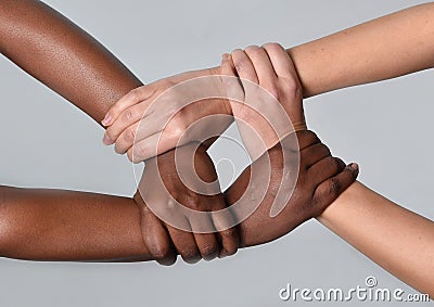 White Caucasian female and black African American hands holding together against racism and xenophobia Stock Photo