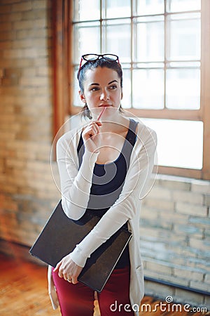 White Caucasian young brunette woman student, female drawing designer artist, in hall of college university Stock Photo