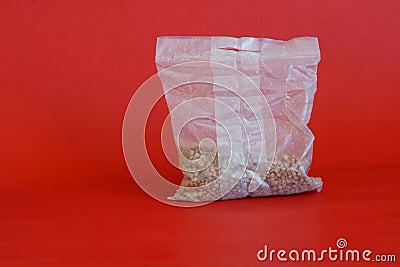 White cellophane cooking bag for preparing quick-digesting steamed buckwheat. Red background Stock Photo