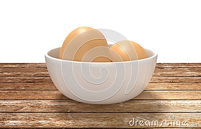 White ceramic bowl ful of eggs. Placed on wooden table. Stock Photo