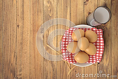 White ceramic bowl ful of eggs. Placed on wooden table. Stock Photo