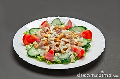 White ceramic plate with fresh tomatoes, cucumber, celery, lettuce and meat salad Stock Photo