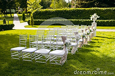 White chairs on a green lawn for a wedding ceremony are waiting for guests Stock Photo