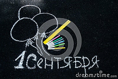 White chalk on black asphalt inscription in Russian September 1. yellow line, colorful markers, painted balls Stock Photo