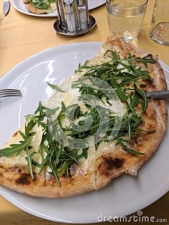 White cheese half pizza pie with arugula on a plate Stock Photo