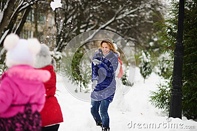 White Christmas. Girl plays with mother in snowballs in the winter park. Stock Photo