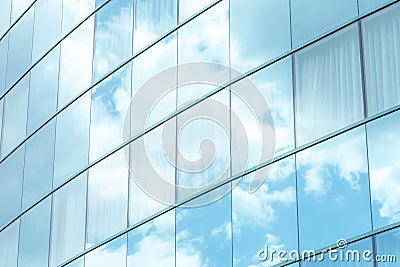 White clouds reflecting in simple modern generic office building square windows, skyscraper exterior, bright blue white background Stock Photo