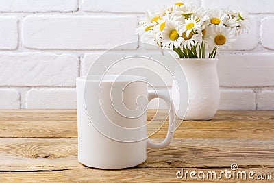 White coffee mug mockup with chamomile bouquet in rustic vase Stock Photo