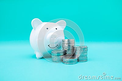 White color piggy bank with coins pile step up growing business to success and saving for retirement concept Stock Photo