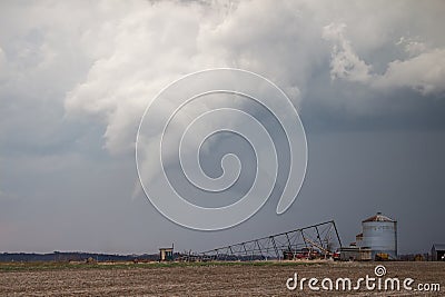 White cone tornado beneath a storm cloud over rural farmland Stock Photo