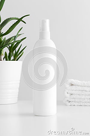 White cosmetic spray bottle mockup with a aloe vera and towels on a white table Stock Photo