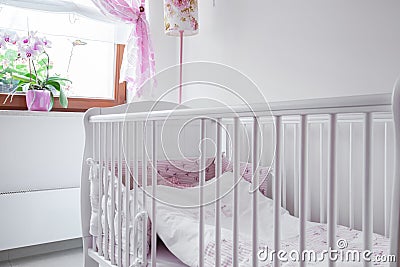 White crib in nursery room Stock Photo