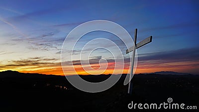 White cross on a hilltop at sunset Stock Photo