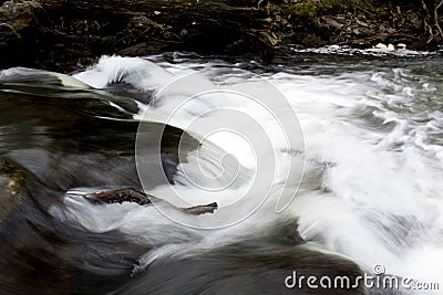 White crystal clear river stream rushing over rocks Stock Photo