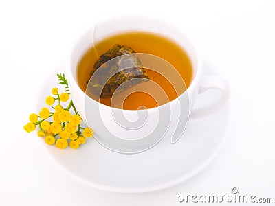 White cup of black tea with tansy plant Stock Photo
