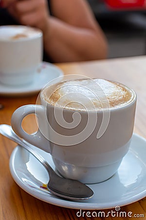White cup with cappucino coffee with whipped hot milk Stock Photo