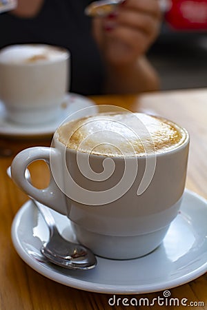 White cup with cappucino coffee with whipped hot milk Stock Photo