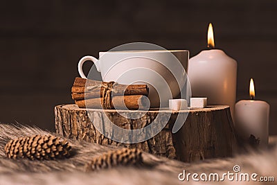 White cup with coffee, candles, cinnamon, sugar, fur and cones Stock Photo