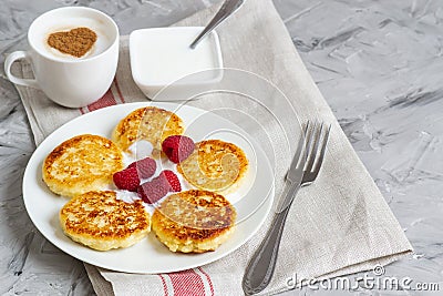 White Cup of Coffee Cappuccino with Heart Pattern of Cinnamon, Cottage Cheese Pancakes with Raspberries Stock Photo