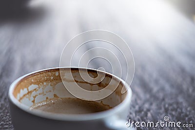 White cup of coffee with half full of coffee and bubble foam Stock Photo