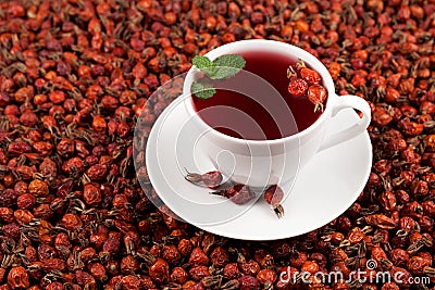 White cup of herbal hibiscus tea and dried rosehips against a background of dried rosehip berries. Close-up, selective focus Stock Photo