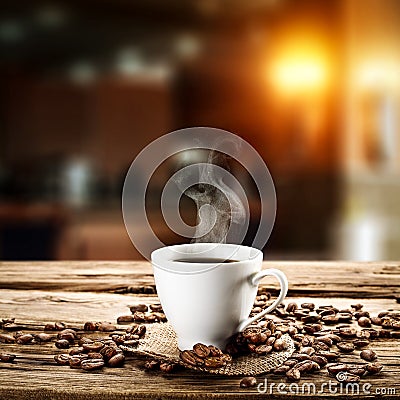 A white cup of hot coffee on wooden table with dark blurred background. Stock Photo