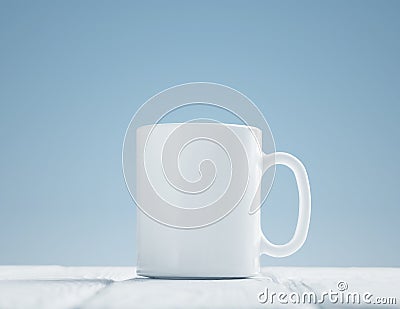 White cup mock-up inclined on wooden table Stock Photo