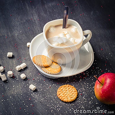 White cup on a saucer with hot cocoa. Morning breakfast. Dark wooden background. Stock Photo