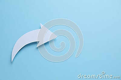 White curved paper arrow on light blue background, top view. Space for text Stock Photo