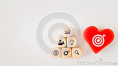 White dartboard sign on red heart and pyramid of business icon on wood cubes with copy space, brainstorming, target, goal concept Stock Photo