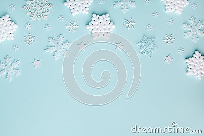 White decorative snowflakes on turquoise pastel background. Christmas or New year holiday card top view. Minimalistic flat lay Stock Photo