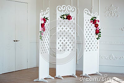 White delicate decorative wood panel in classical interior. Boudoir wedding room. Retro folding screen with flowers Stock Photo