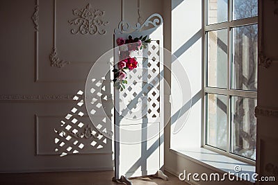 White delicate decorative wood panel in classical interior. Boudoir wedding room. Retro folding screen with flowers Stock Photo